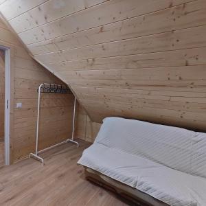 a bed in a room with a wooden ceiling at beskid.house2 in Spytkowice