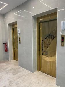 eine Lobby mit zwei Aufzügen und einer Treppe in einem Gebäude in der Unterkunft الماطر للشقق الفندقية Almater Hotel Suites in Al Khafji