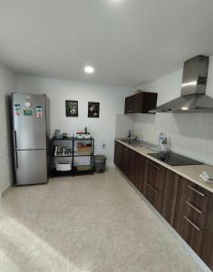 a kitchen with a stainless steel refrigerator and cabinets at Vivienda Vacacional Casa del Erizo - Ecofinca in Nazaret