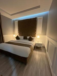 1 dormitorio con 1 cama grande con luz azul en الماطر للشقق الفندقية Almater Hotel Suites, en Al Khafji