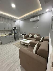 ein Wohnzimmer mit einem Sofa und einem Tisch in der Unterkunft الماطر للشقق الفندقية Almater Hotel Suites in Al Khafji