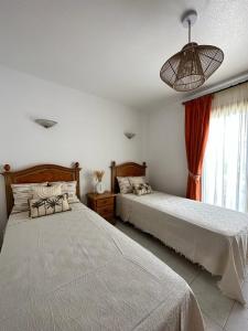 1 Schlafzimmer mit 2 Betten und einem Fenster in der Unterkunft Palm View Apartment Vera Coast in Playas de Vera