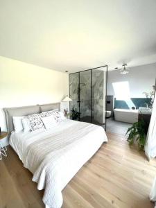 biała sypialnia z dużym łóżkiem i szklaną ścianą w obiekcie Dom z widokiem na góry stołowe i dużym ogrodem w Kłodzku