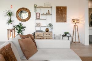 uma sala de estar com um sofá e um espelho em Casa Nascer do Sol em Atouguia da Baleia
