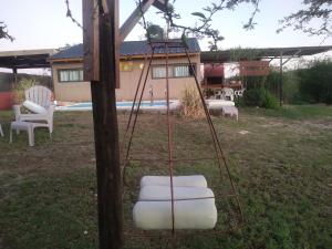 un columpio con sillas blancas en un patio en Los Frutales en Villa Carlos Paz