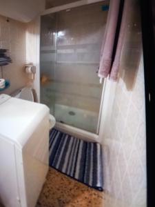 une salle de bain avec une douche avec une porte vitrée dans l'établissement Studio plage karina, à Empuriabrava