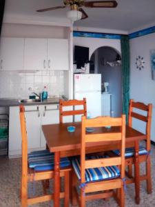 une cuisine avec une table en bois et deux chaises dans l'établissement Studio plage karina, à Empuriabrava