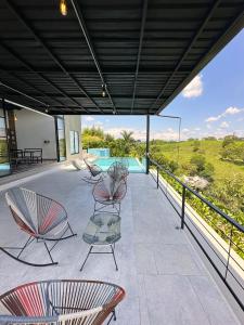 un patio con sillas, mesas y una piscina en Eco Hotel La Colina Mirador, en Quimbaya