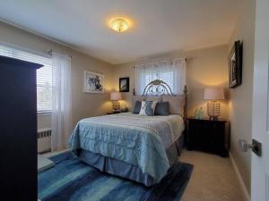 ein Schlafzimmer mit einem Bett, zwei Lampen und einem Fenster in der Unterkunft Long Beach Paradise by the Sea (3 bed/2 bath) in Long Beach
