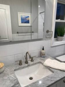 ein Bad mit einem Waschbecken und einem Spiegel in der Unterkunft Long Beach Paradise by the Sea (3 bed/2 bath) in Long Beach