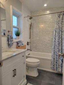 a bathroom with a toilet and a tub and a sink at Long Beach Paradise by the Sea (3 bed/2 bath) in Long Beach