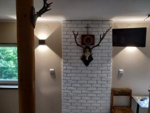 um quarto com uma parede de tijolos com um relógio e luzes em Domek w Bieńkówce 