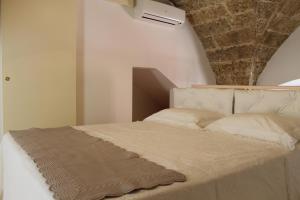 sypialnia z białym łóżkiem i kamiennym sufitem w obiekcie B&B Nino Moro w mieście Casarano