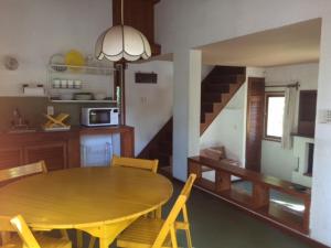 cocina y comedor con mesa de madera y sillas en Rincon del Bosque - Tritones 790 en Pinamar