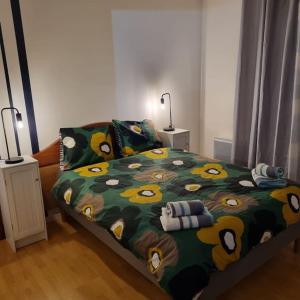 1 dormitorio con 1 cama con edredón verde y amarillo en Grand appartement confortable, en Andolsheim