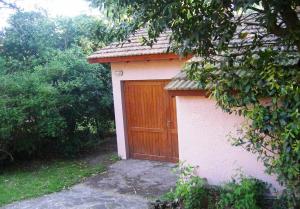 a smallshed with a wooden door in a yard at Rincon del Bosque - Tritones 790 in Pinamar