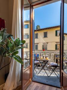 a balcony with a view of a patio with a table at Flower House - Dolcevita Holiday in Florence