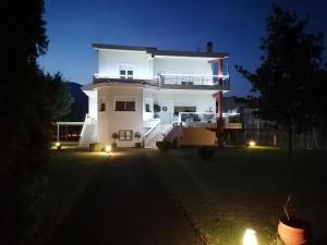 uma casa branca com uma varanda à noite em Village Villa 