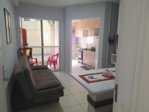 uma sala de estar com um sofá e uma cozinha em Apartamento flat em condomínio club em Aracaju