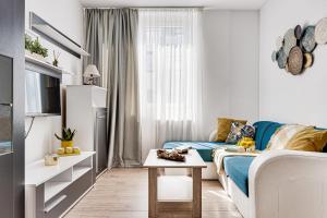 a living room with a couch and a table at Dodi Blue Apartament in Arad