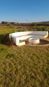a white bench sitting in the middle of a field at Marina Golf appartement de luxe in Asilah