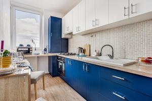 a kitchen with blue cabinets and a sink at Dodi Blue Apartament in Arad