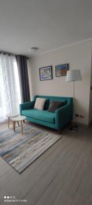 a living room with a green couch and a table at Departamento nuevo y cómodo in Santiago