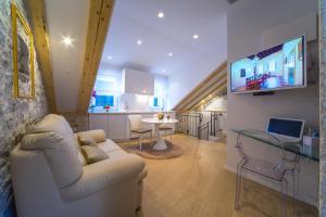 ein Wohnzimmer mit einem weißen Sofa und einem TV in der Unterkunft Apartment Roman Heritage in Split