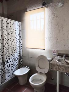 baño con aseo y lavabo y ventana en Solares de Tanti en 