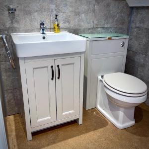 a bathroom with a white sink and a toilet at Sibton White Horse Inn in Saxmundham