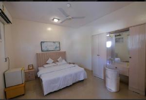 a bedroom with a white bed and a bathroom at استراحة الضبيانية in AlUla