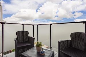 a balcony with two chairs and a table at Dodi Blue Apartament in Arad