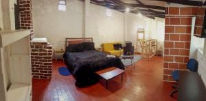 ein Schlafzimmer mit einem Bett in einem Backsteinzimmer in der Unterkunft Aparta Estudios en la Plaza de Toros in Bogotá