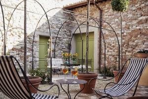 two glasses of wine on a patio with two chairs at Villa Medicea di Lilliano in Grassina
