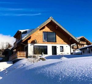 una casa con la neve per terra davanti di Appartement Tannenhof III a Ramsau am Dachstein