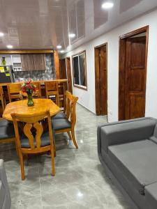 comedor con mesa, sillas y sofá en Casas Manatwar`s en San Andrés