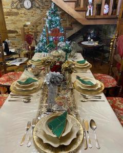 una mesa con platos y cubiertos y un árbol de Navidad en Casa Elvira, en Marquiño