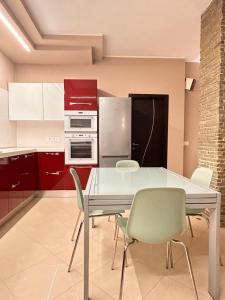 a kitchen with a glass table and chairs at Alloggio Olimpico PalaAlpitour in Turin