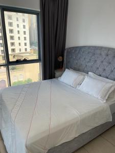 a large bed in a bedroom with a large window at Bellehomez in Dubai