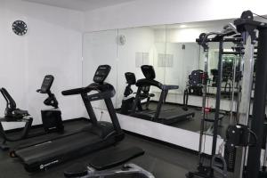 a gym with several tread machines and a mirror at Bellehomez in Dubai