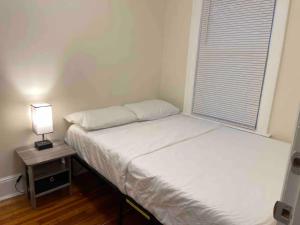 a bedroom with two beds and a table with a lamp at Entire Beautiful 2BR Apartment [L]. Convenient location in the heart of Queens! in Whitestone