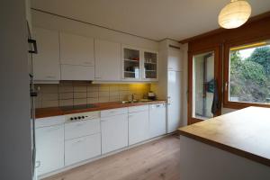 a kitchen with white cabinets and a counter top at Sonniges Haus bei Bern in Herrenschwanden