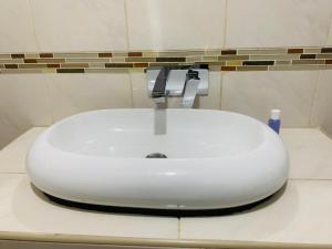a white sink sitting on a counter in a bathroom at AfrikaWisa at O.R. Tambo International Airport in Kempton Park