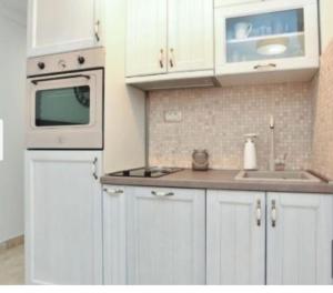 a kitchen with white cabinets and a sink and a microwave at OLD TOWN Budva apart 3 with balcony in Budva