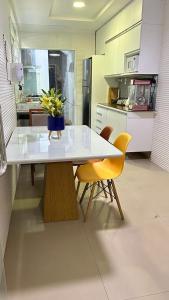 uma cozinha com uma mesa com um vaso de flores sobre ela em Tropical Suítes-Próx Praça da República em Belém