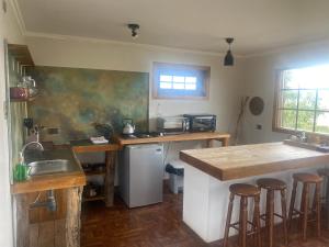 a kitchen with a sink and a counter with bar stools at Dorotea Vista in Puerto Natales