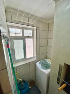 a small bathroom with a toilet and a window at Apartamento 2 quadras do mar centro Capão da Canoa in Capão da Canoa
