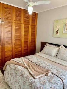 a bedroom with two beds and a wooden cabinet at Apartamento 2 quadras do mar centro Capão da Canoa in Capão da Canoa