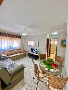 un soggiorno con divano e tavolo di Apartamento 2 quadras do mar centro Capão da Canoa a Capão da Canoa