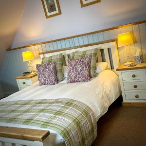 um quarto com uma cama branca com almofadas em Sibton White Horse Inn em Saxmundham